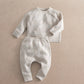 Cream duck-knit 2-piece set with speckle pattern: long-sleeve top and cuffed pants.