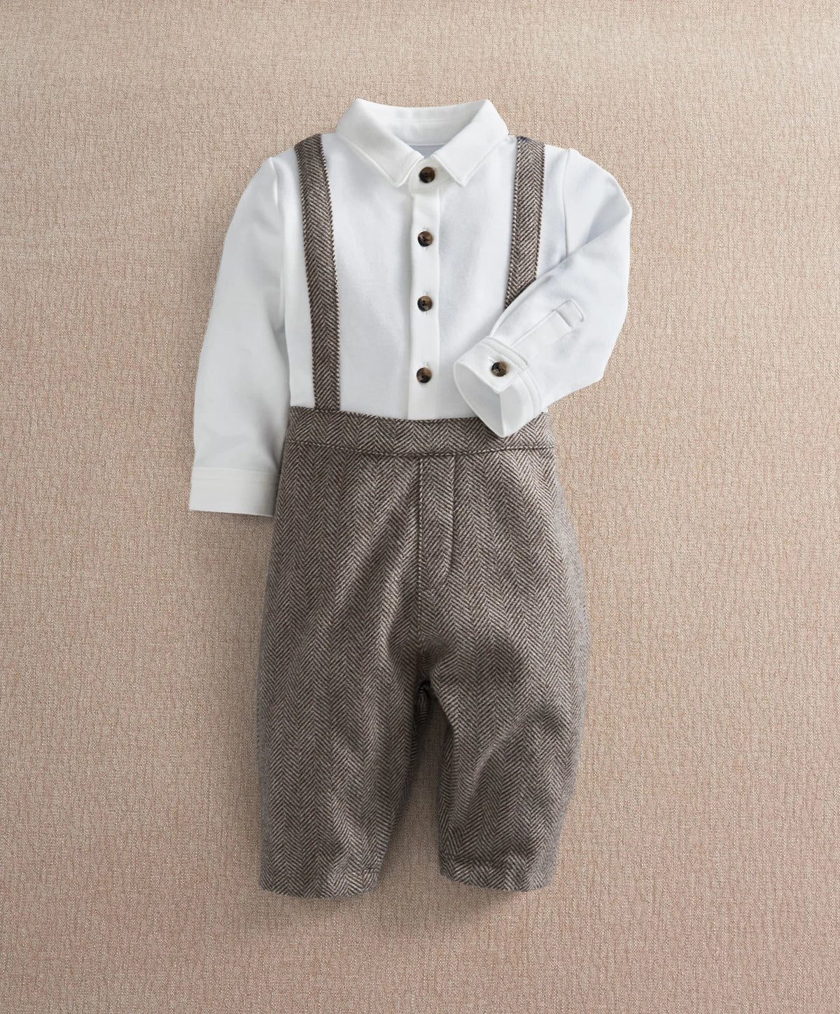 White mock-neck romper with dark herringbone bib and button-up front