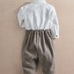 Back view of white-and-dark herringbone romper with buttoned back and gathered waist