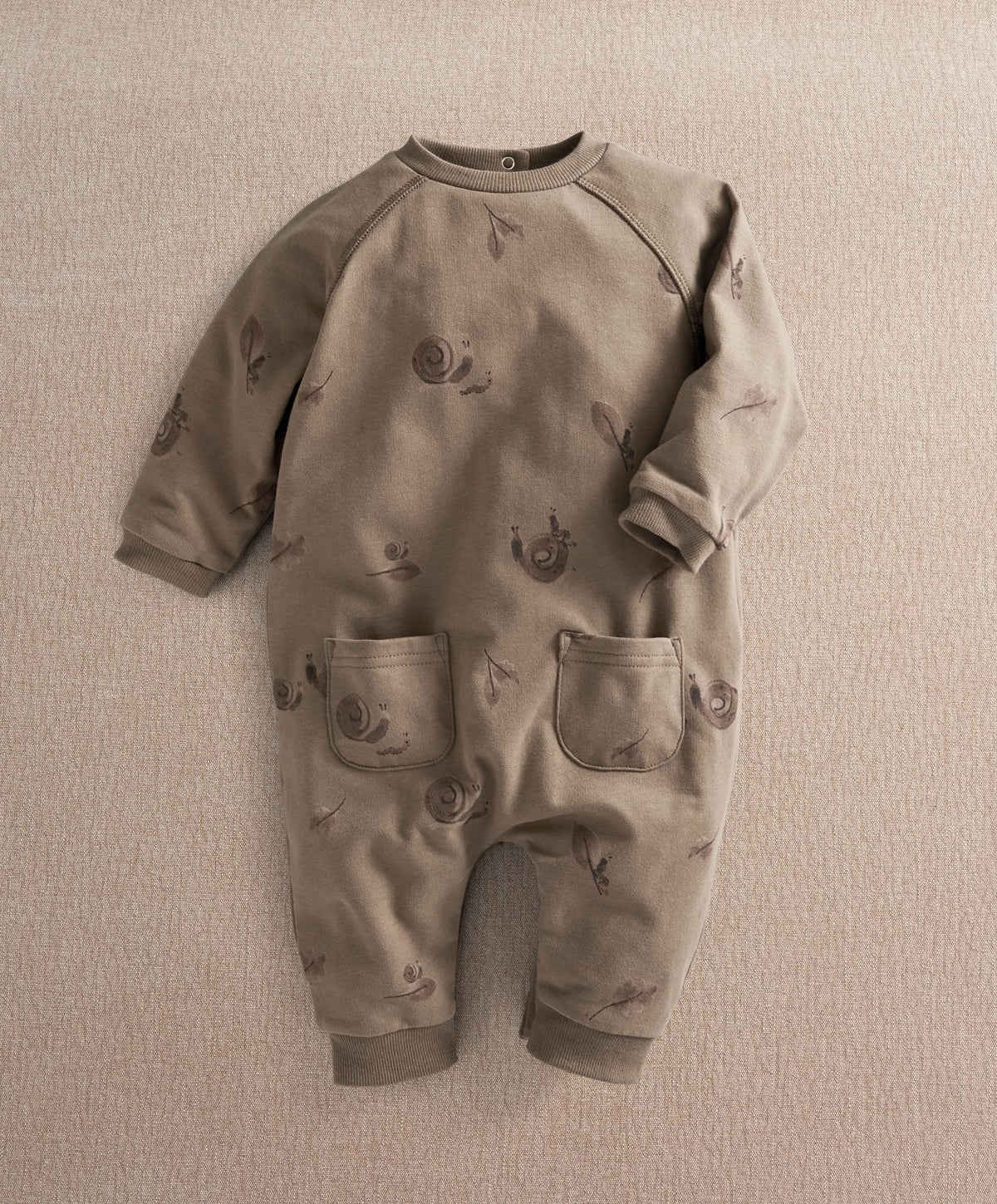 Gray long-sleeve romper with allover snail print and front snap placket