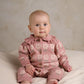 Pink floral knitted baby romper with buttoned front and ribbed collar