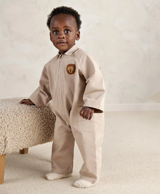 Light tan zip-front romper with turn-down collar, bear patch, and front patch pockets