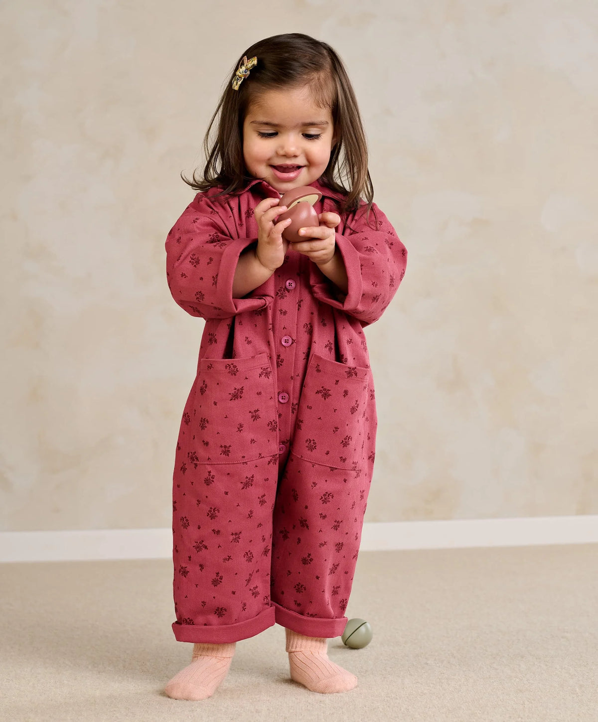 Purple floral short-sleeve romper with button front and patch pockets, long legs