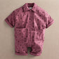 Purple floral short-sleeve romper with button front and two chest patch pockets