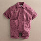 Purple floral short-sleeve romper with button front and two chest patch pockets