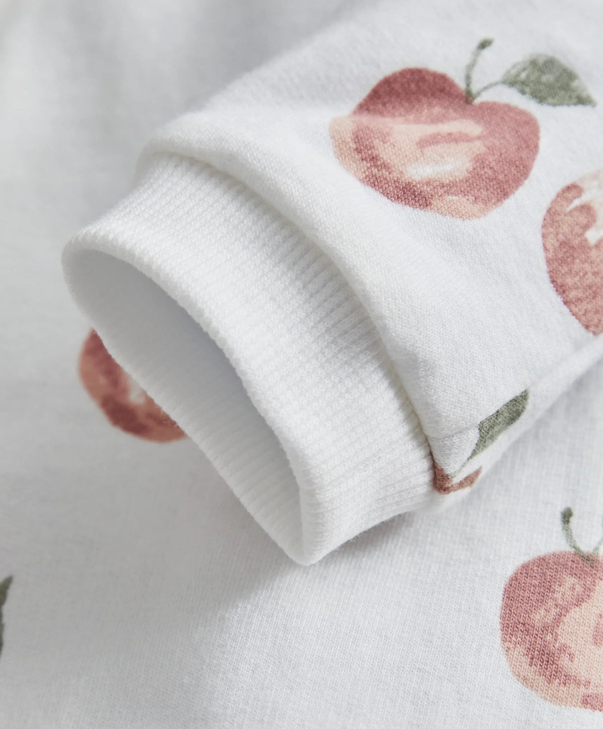 White fruit-print romper sleeve with folded ribbed cuff and fruit motif