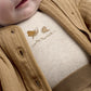 Beige embroidery on jacket, featuring snail and rainbow stitch design