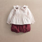 White long-sleeve top with floral embroidered collar, button front, ruffle cuffs.
