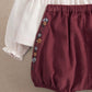 Burgundy bloomer shorts with floral side embroidery and elastic waistband.