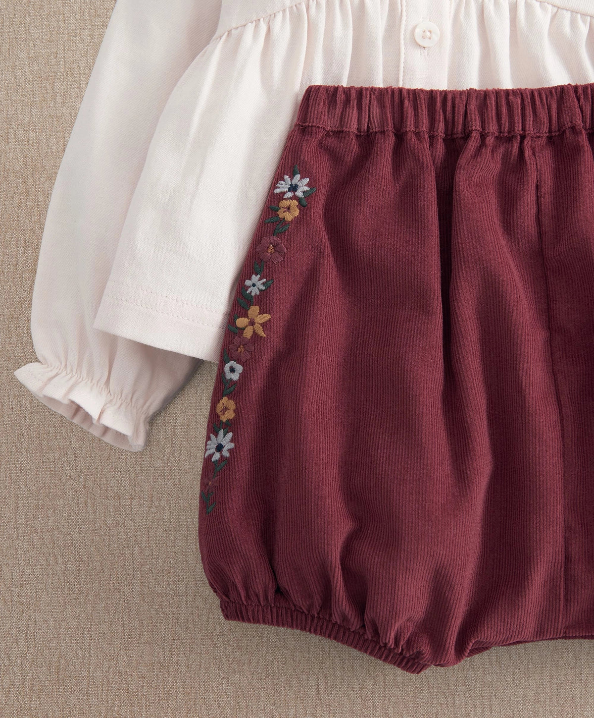 Burgundy bloomer shorts with floral side embroidery and elastic waistband.