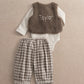 Brown borg waistcoat with 'Taylor' text, white bodysuit, and gray plaid trousers