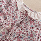 Ditsy floral baby romper close-up of embroidered ruffle collar and buttons