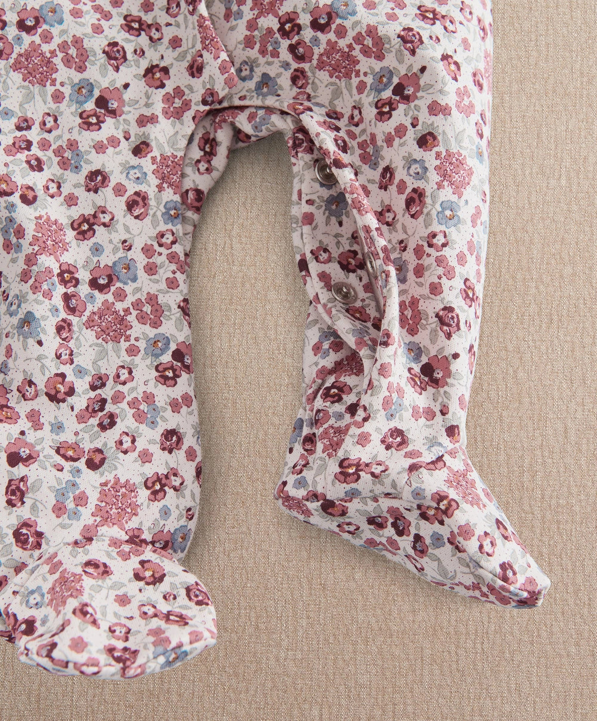 Ditsy floral baby romper with open back and rounded leg openings