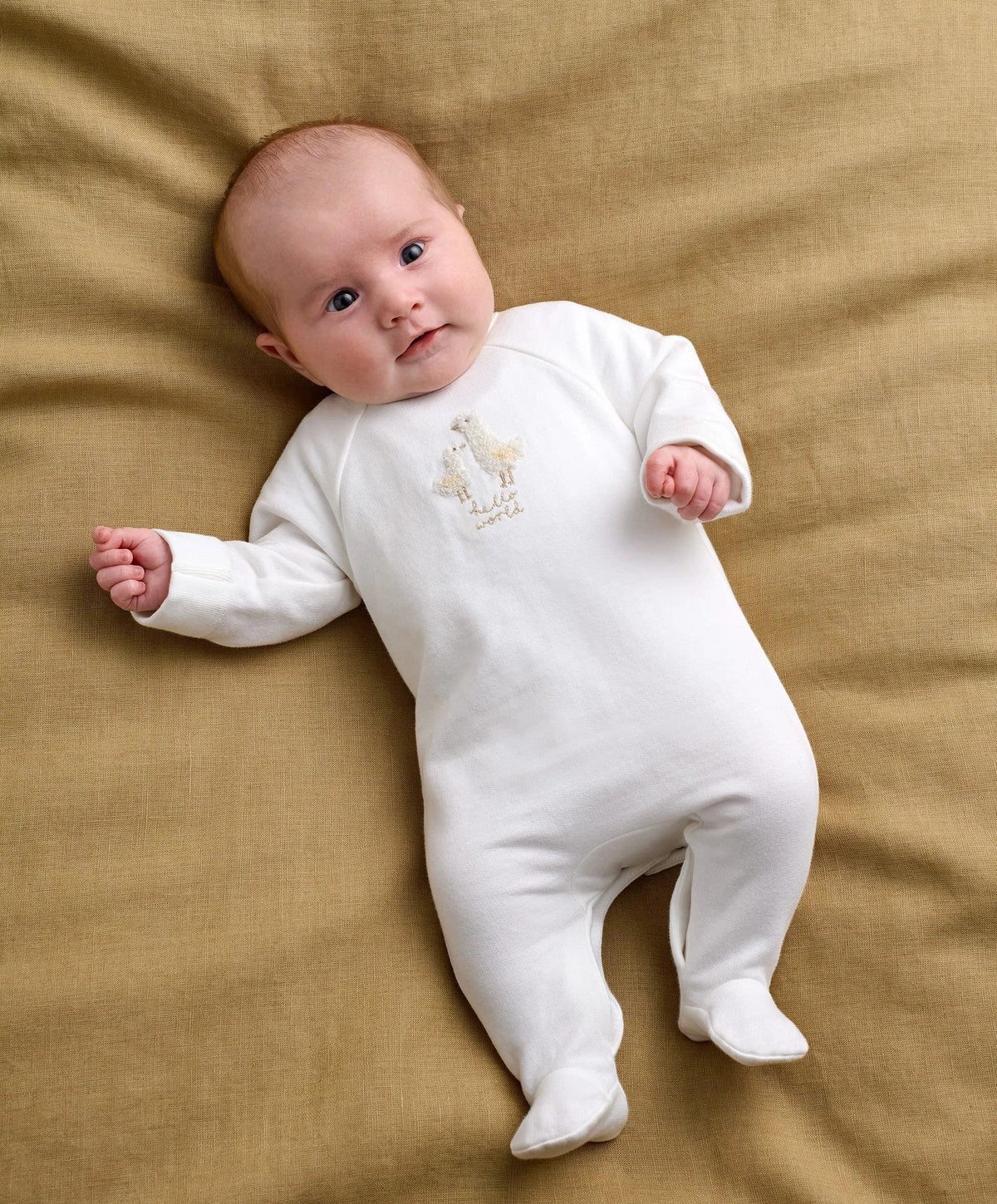 White baby all-in-one romper with duck embroidery, long sleeves and footed legs