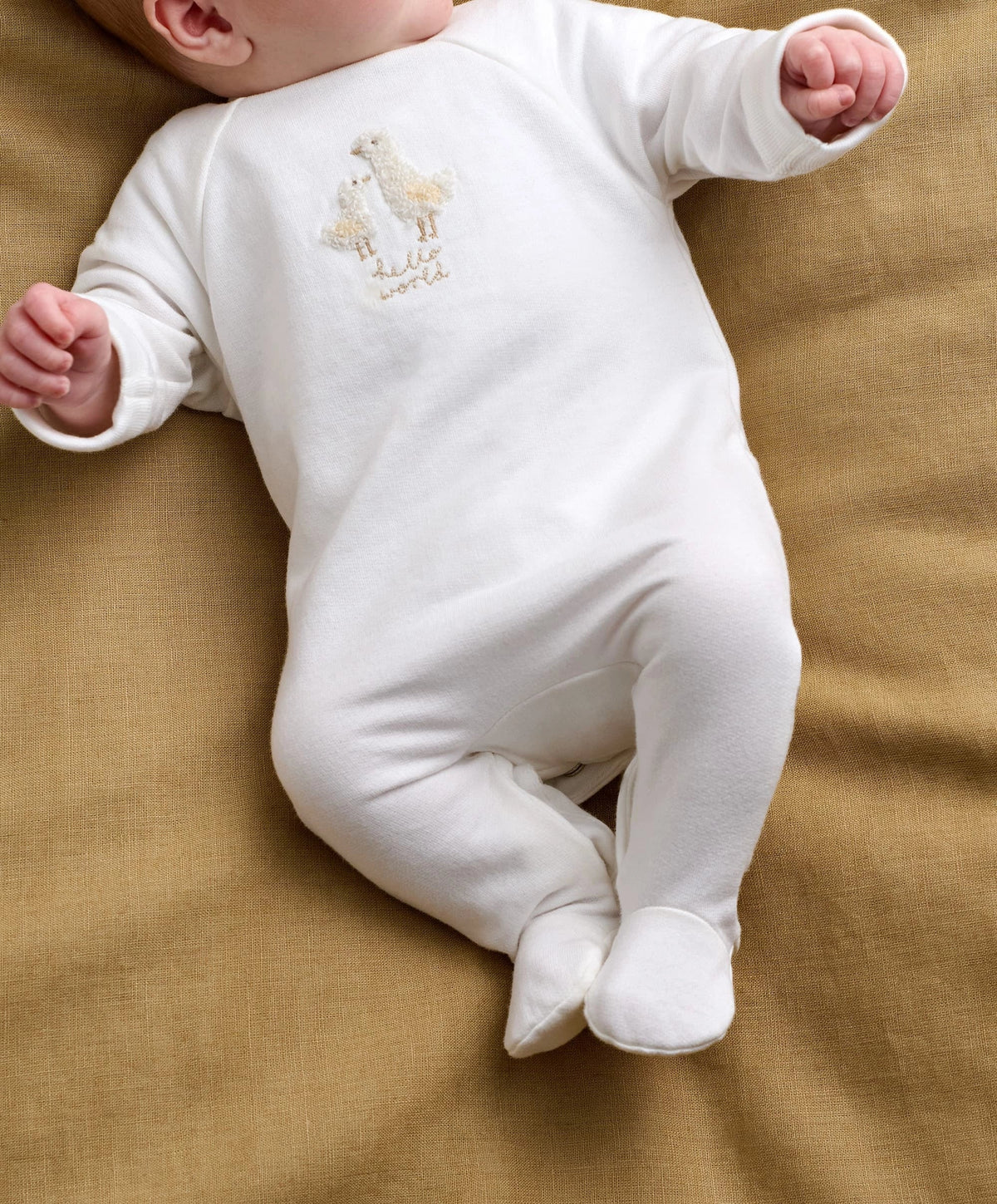 White baby all-in-one romper with duck Hello World embroidery on front