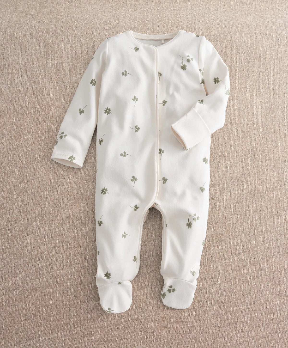 White clover-print long-sleeve baby romper with snaps and footed bottoms