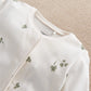 Clover-print baby romper with ribbed neckline and snap buttons