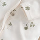 Clover-print baby romper close-up with button placket and long sleeves
