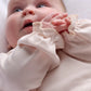 Pink baby onesie with ruffled cuffs and collar