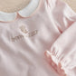 Pink baby onesie with embroidered bear, 'born in 2027' and ruffled sleeve cuffs