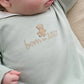 Light blue baby sleepsuit with embroidered bear and 'Born in 2027' lettering