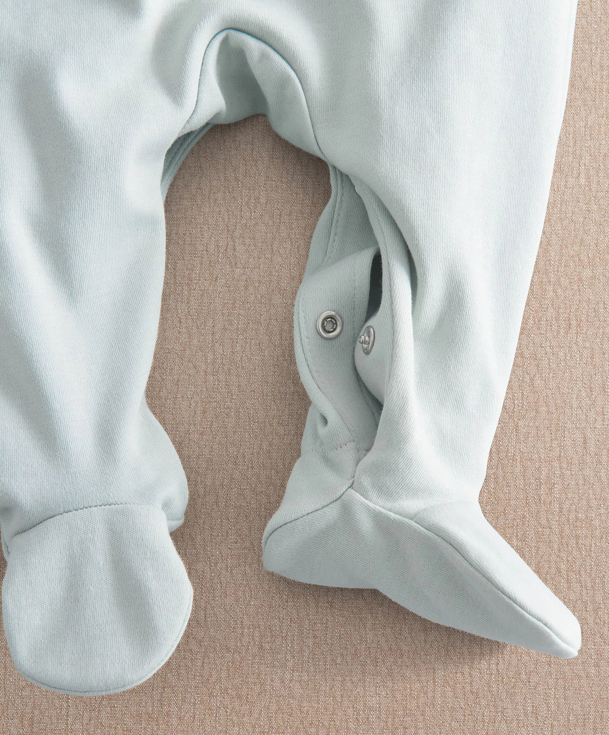 Light blue baby sleepsuit showing foot opening with snap buttons