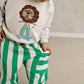 White toddler sweatshirt with lion face applique, teal ribbed neckline and cuffs