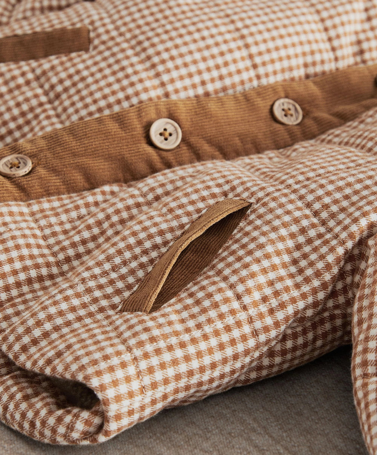 Checked jacket chest pocket detail with corduroy panel and button snaps