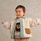 Cream borg jacket with mint lining, blue trim, tan pockets, and wooden button front