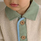 Cream borg jacket close-up with mint collar band and wooden buttons
