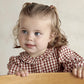 Red and white gingham dress close-up with ruffled collar and long puff sleeves