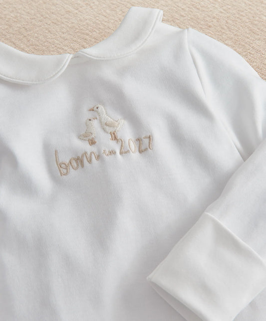 White baby romper with long sleeves and embroidered "born in 2027" logo