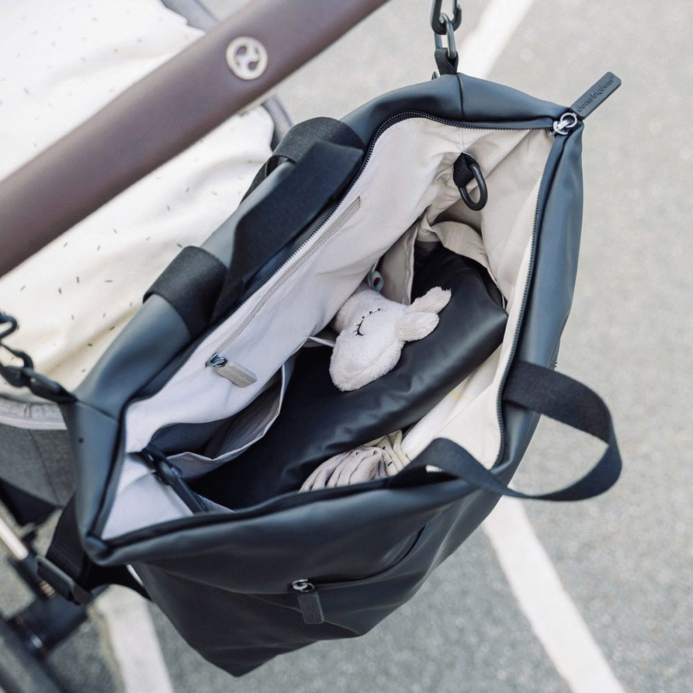 Black changing backpack with zip-open top, adjustable straps, and visible interior
