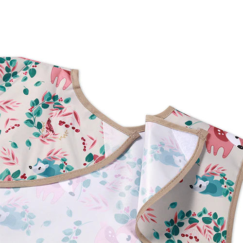 Kids forest animal bib apron with round neckline and beige trim; sleeveless