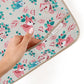 Forest animal print apron with beige binding and a visible pocket inner label