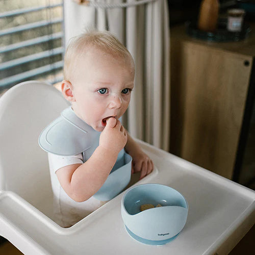Blue silicone bib on baby, round neck strap and front catch pocket