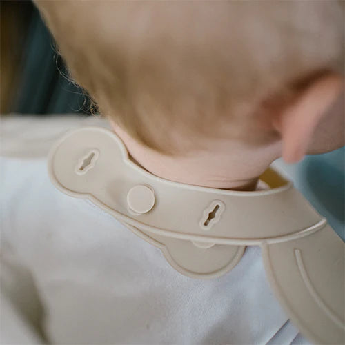 Beige silicone bib neck strap detail with adjustable holes and lock