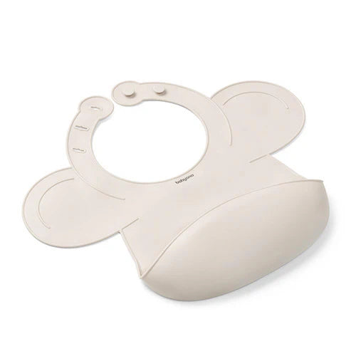 Beige silicone baby bib with adjustable lock, curved wings, and front pocket