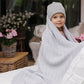 Grey cotton knitted blanket with chevron knit, hooded over a child’s head