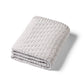 Grey cotton knitted blanket with textured chevron stitch, neatly folded
