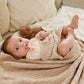 Cotton knitted blanket in beige with chevron knit texture, baby lying on blanket