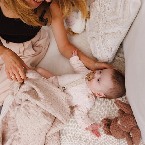 Merino wool blanket, light beige knit spread as toddler rests