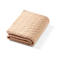 Merino wool blanket in dark beige knit, folded with textured cable pattern