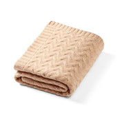 Merino wool blanket in dark beige knit, folded with textured cable pattern