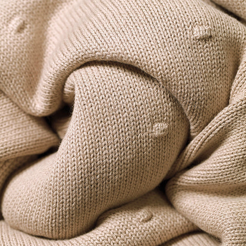 Flannel-lined cotton blanket close-up with thick knit texture and folded seam