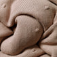 Cotton blanket with flannel lining corner close-up in tan knit fabric with rounded seam