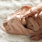 Pink hooded baby towel with face applique, laid open