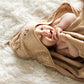 Beige hooded towel on a baby, with hood detail and small face