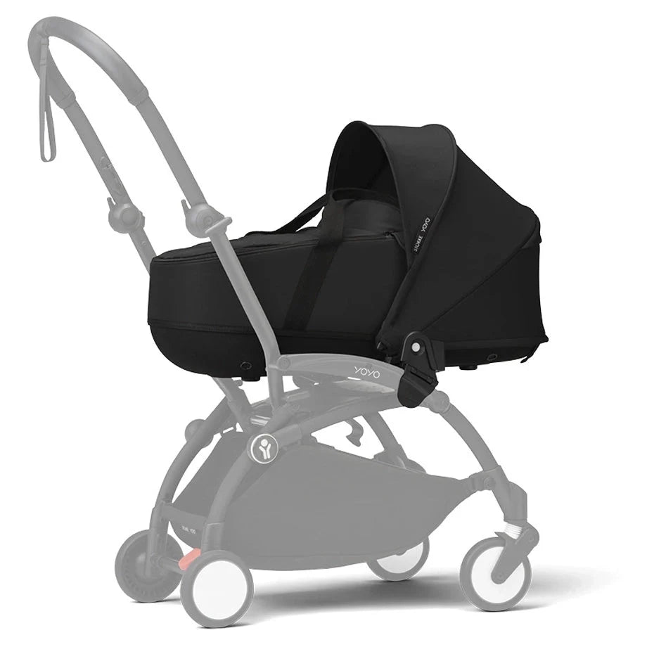 Black newborn carrycot attached to a stroller with light gray frame and wheels.