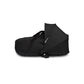 Black newborn carrycot with foldable hood and carry handle, shown on its side.